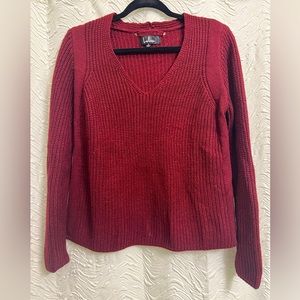 Cozy red sweater; slightly cropped fit.